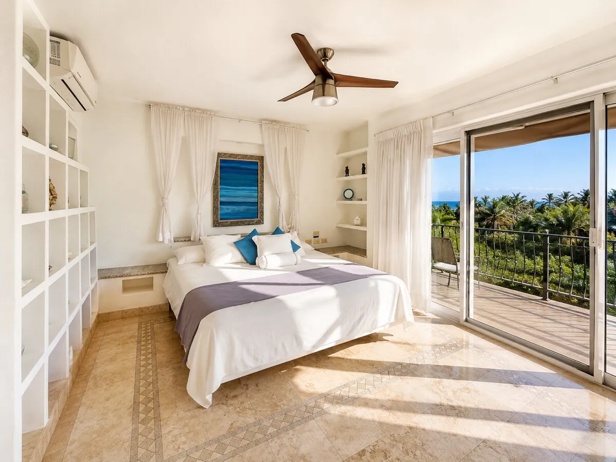 The primary bedroom, with its balcony and ocean view